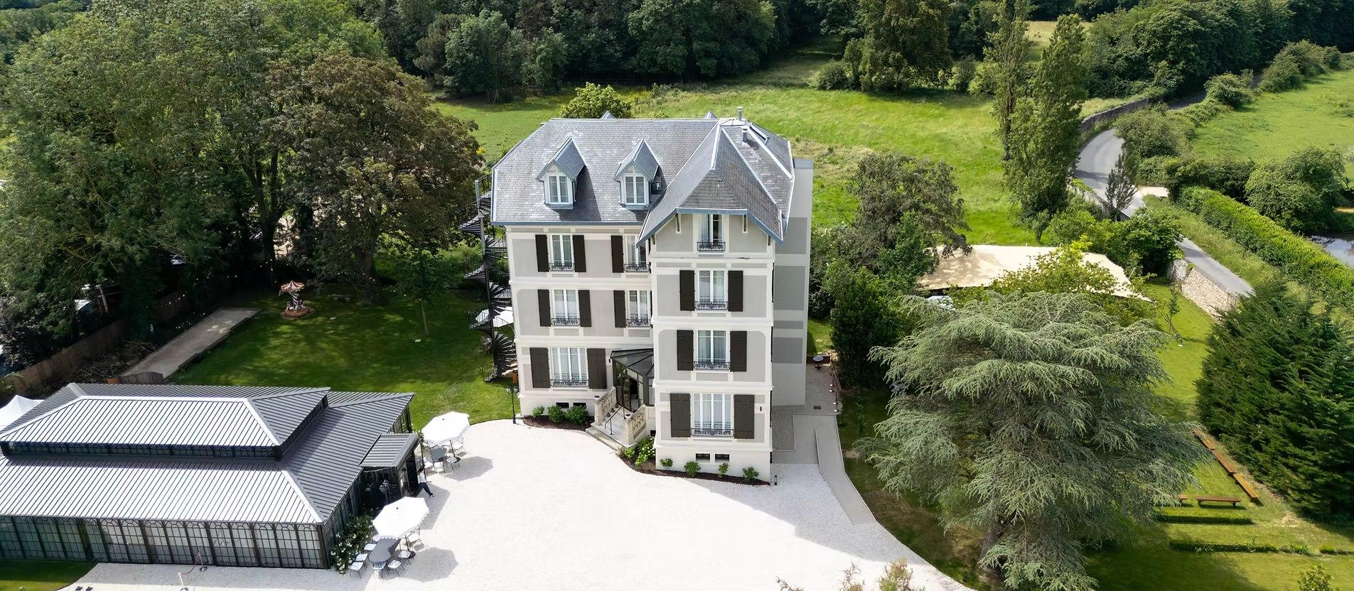 Escalier monumental en bois préservé dans une villa transformée en hôtel